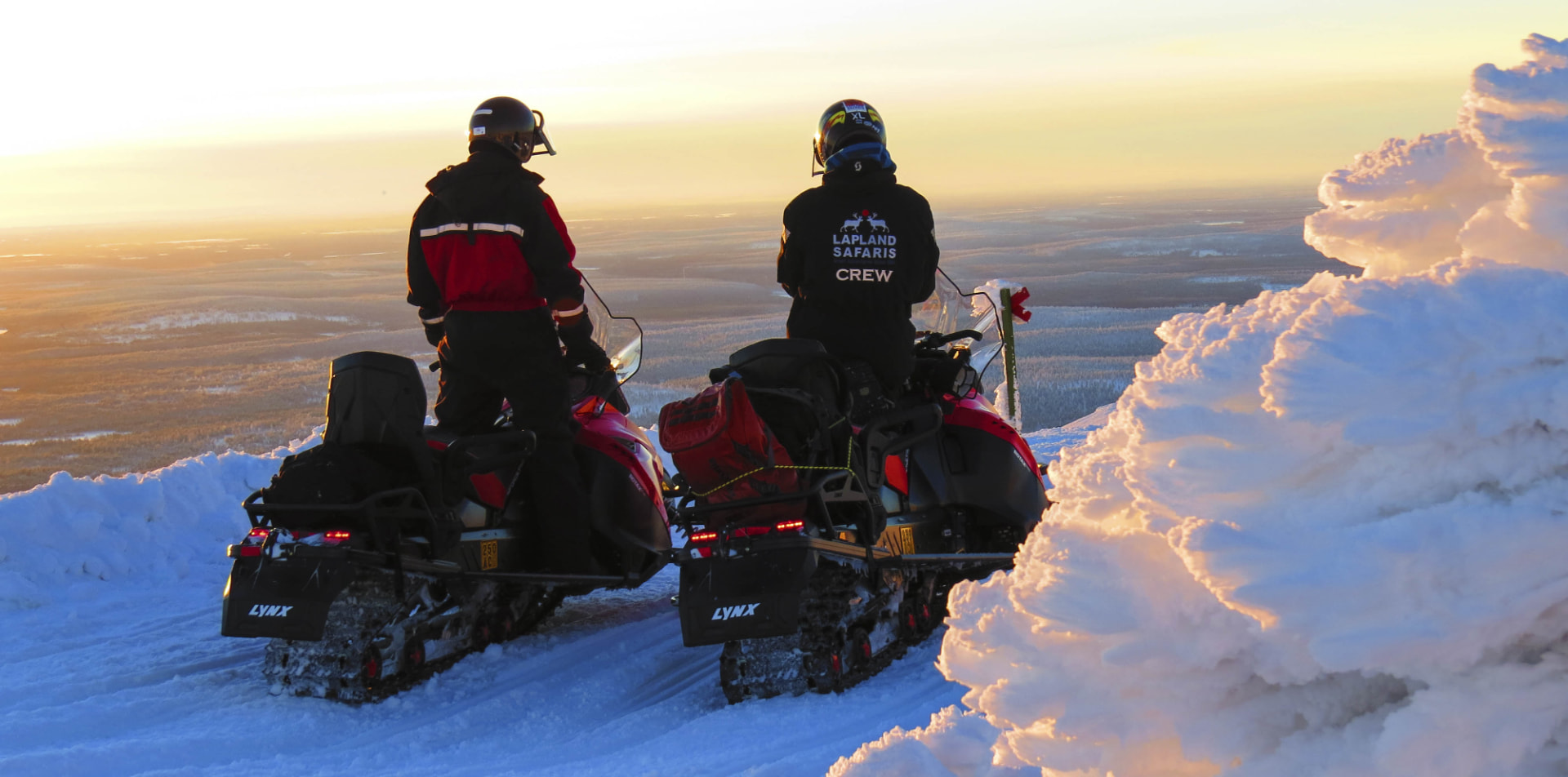 Two riders pausing on a fell top above the Lapland forest in golden light