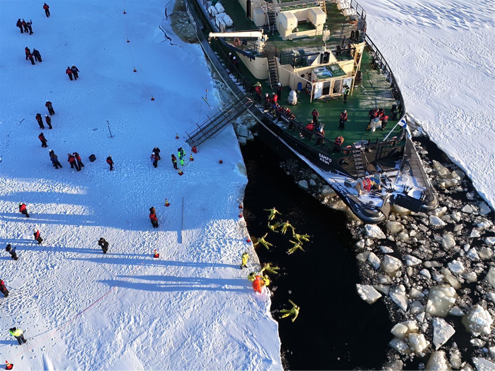 Aerial view of the icebreaker Sampo moored in the frozen Bothnian Bay with guests on the ice