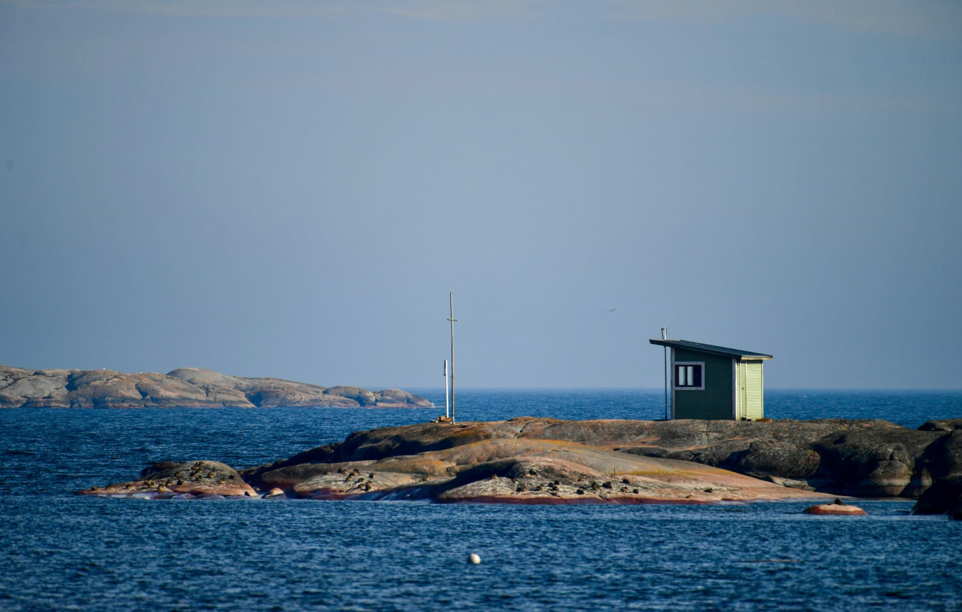 A lone cabin on a bare granite skerry in the outer archipelago under open sky