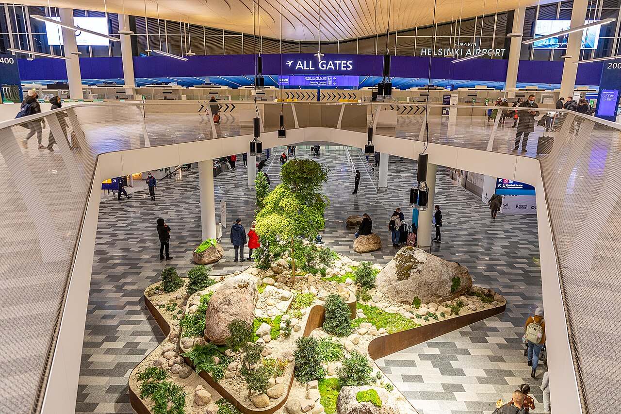 Arrivals hall at Helsinki Airport with a stone and pine garden below the departure level