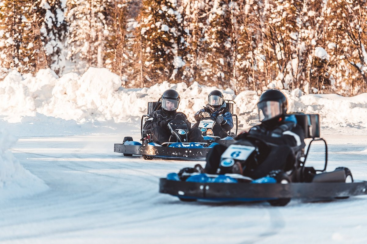 Three karts racing on a snow-banked ice track in Lapland