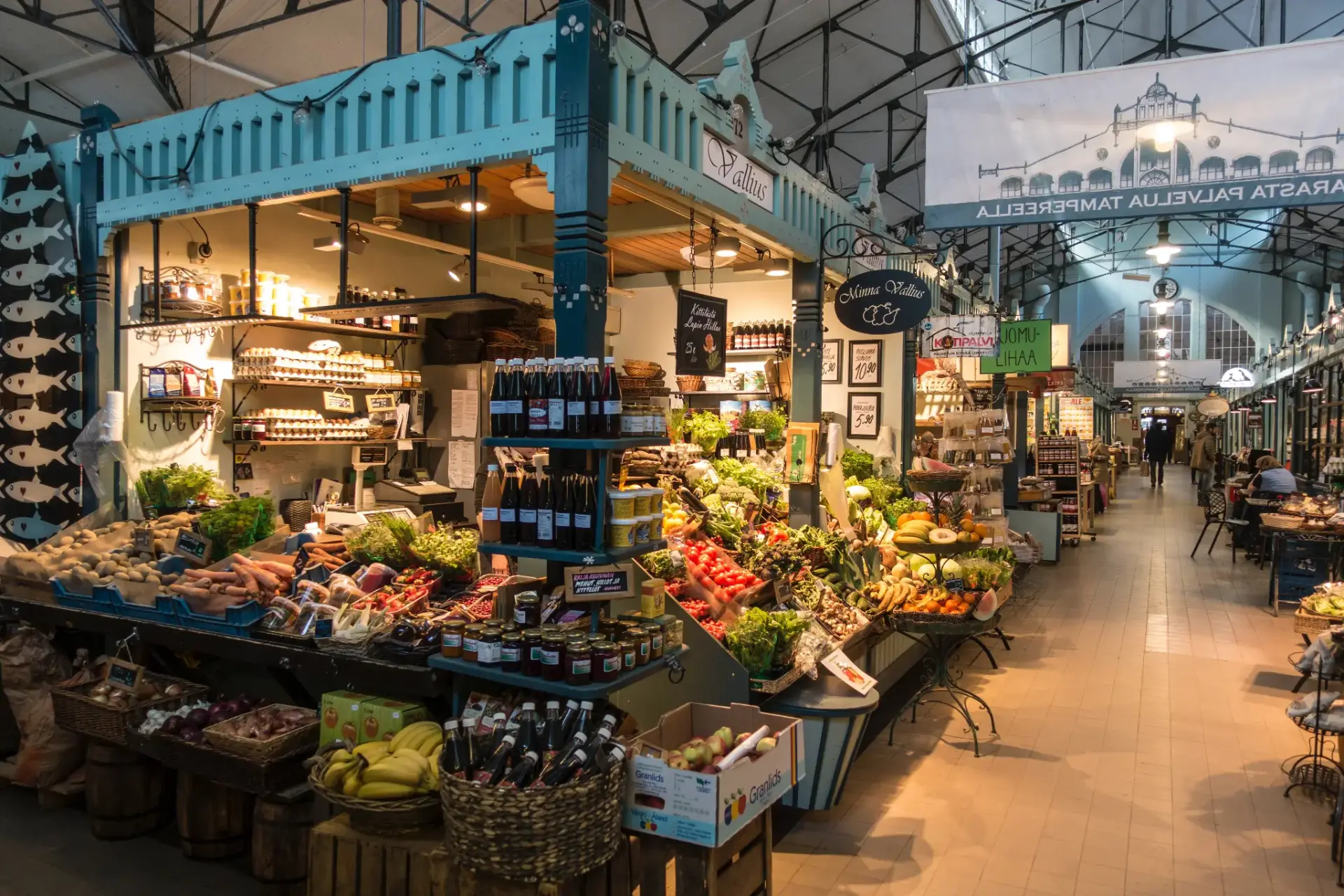 Produce stalls and preserves along the aisle of a Finnish market hall